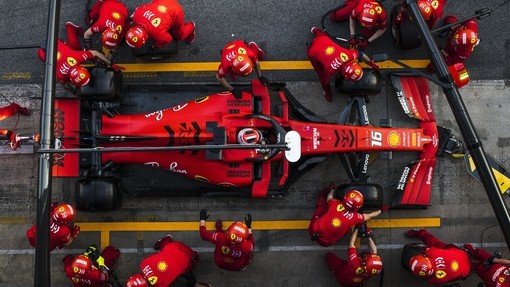 A Ferrari Formula 1 car in the pit stop with team attending
