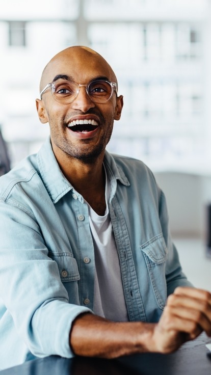 Bald man with glasses laughing